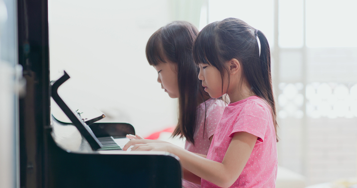 Two Girls Playing the Piano Indoors